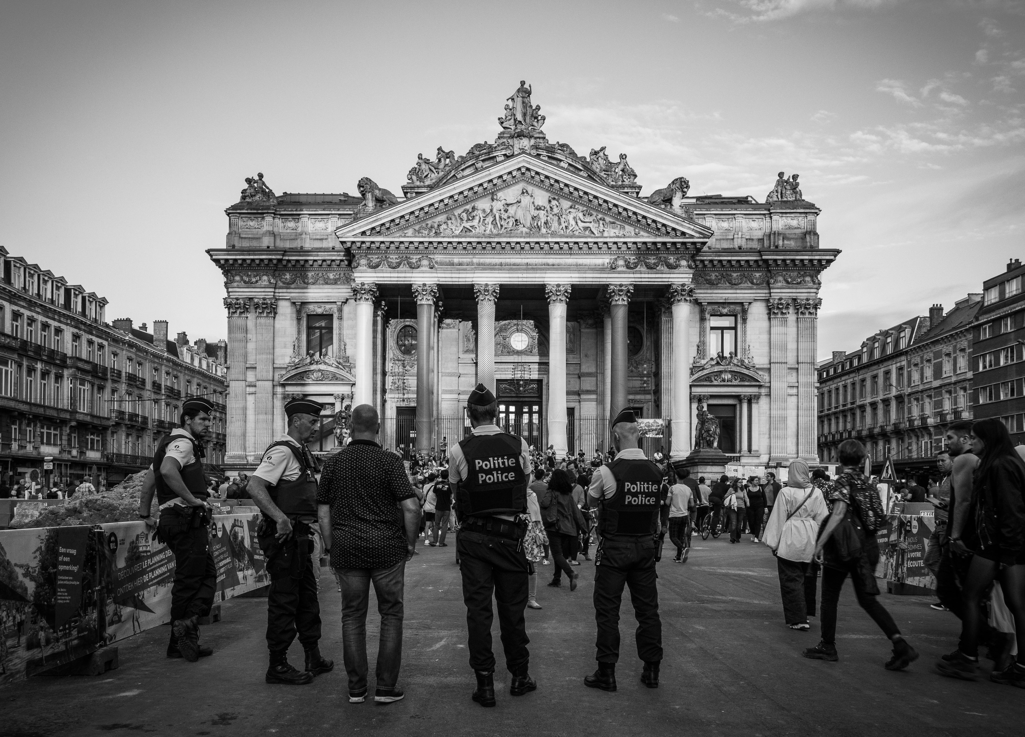 grayscale photography of people standing near building